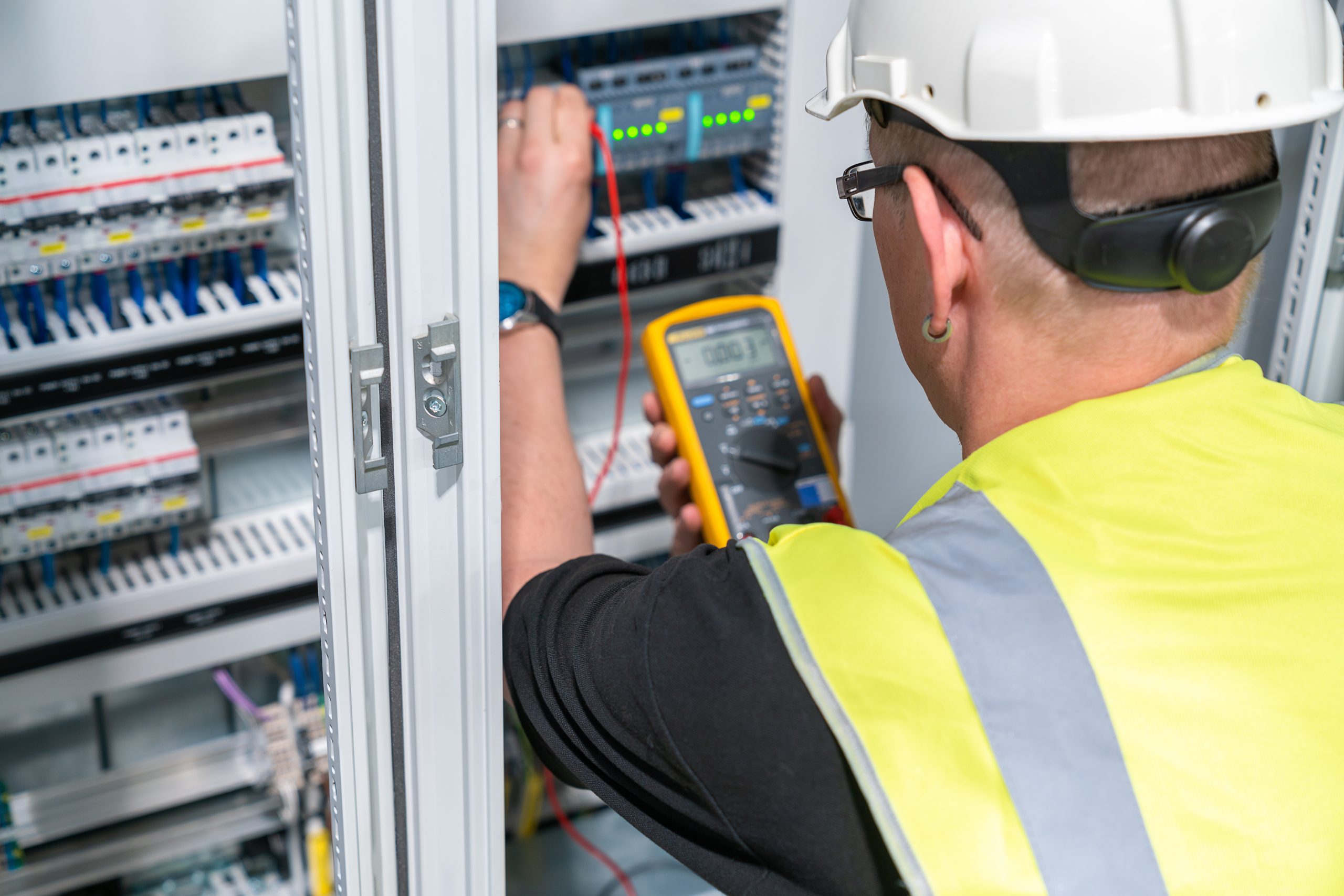 an electrical engineer performs a measurement in a control cabinet electrical engineer performs a measurement in a control cabinet